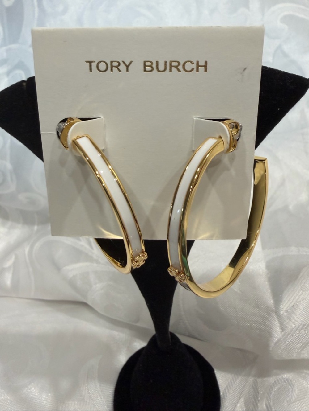 Tory Burch Gold and White Hoop Earrings with Enamel Trim emblem in gold.